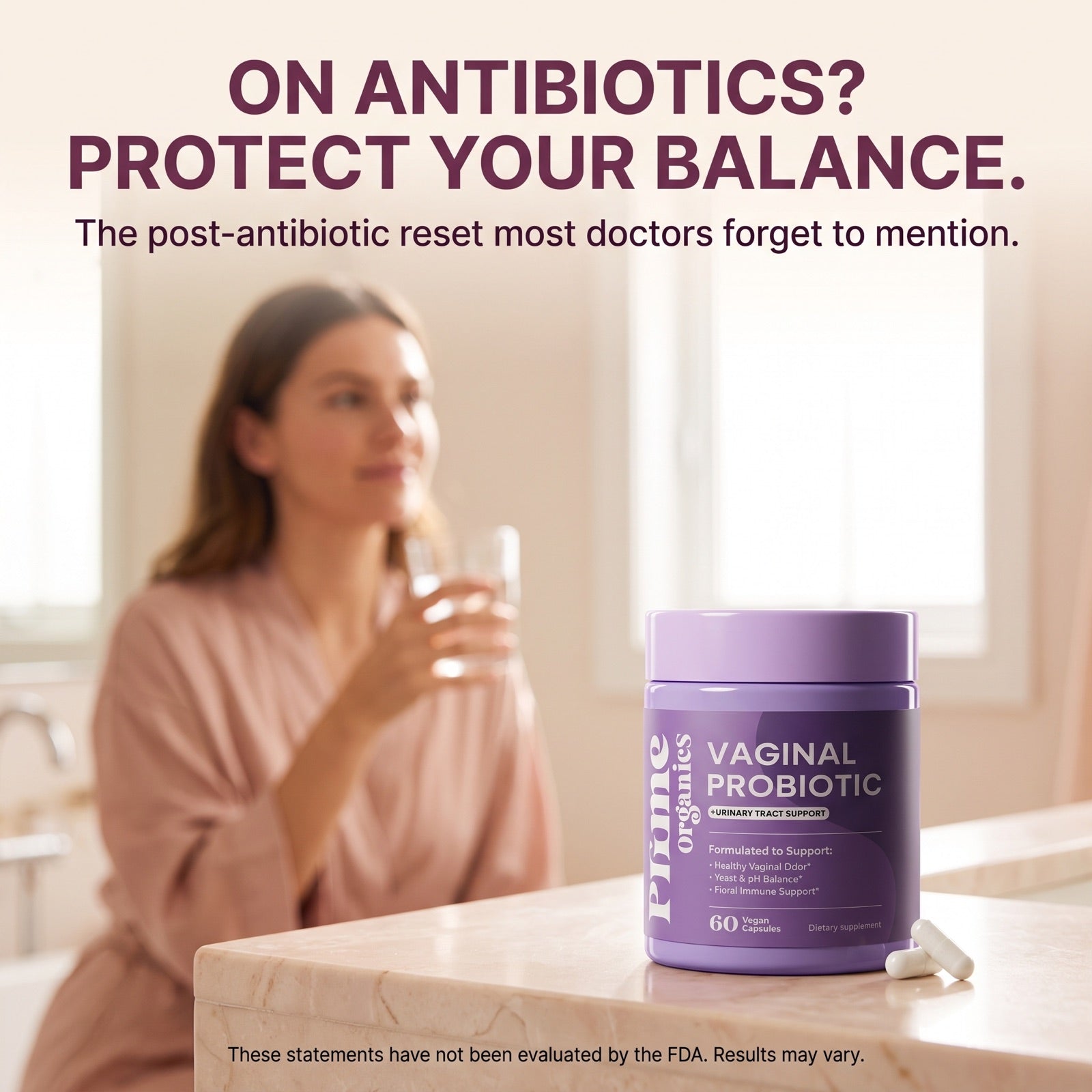 Woman in a robe taking her capsule with water, Prime Organics Vaginal Probiotic on the bathroom counter