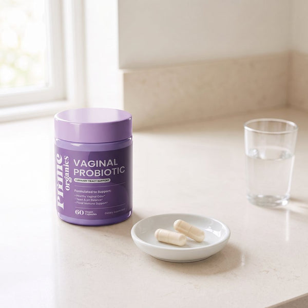 Prime Organics Vaginal Probiotic jar, two capsules in a dish and a glass of water